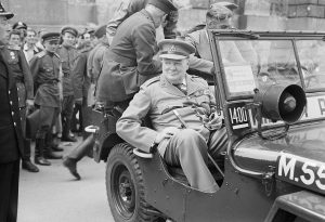 Winston Churchill speeches _in_a_jeep_outside_the_German_Reichstag_during_a_tour_of_the_ruined_city_of_Berlin,_16_July_1945._BU8950